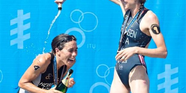 Bronze medalist Andrea Hewitt, left, of New Zealand, is doused with champagne by gold medalist Gwen Jorgensen, of the United States, after the Elite Women's World Championship final. Photo / AP