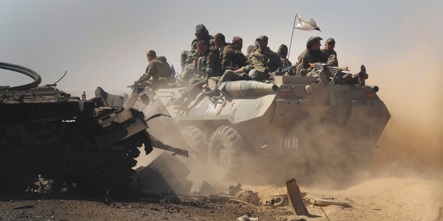 Pro-Russian rebels pass destroyed Ukrainian military vehicles near Novokaterynivka, eastern Ukraine. Photo / AP
