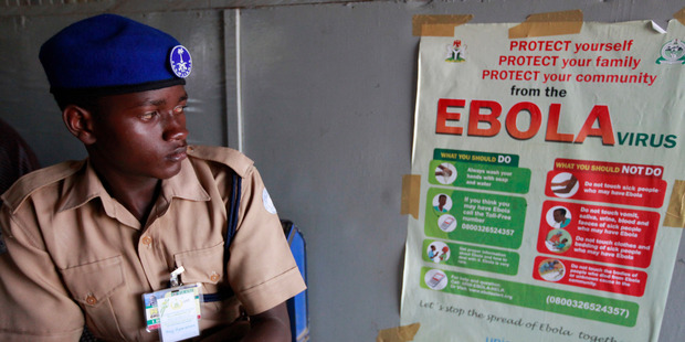A Muslim Hajj worker look at an Ebola campaign poster at the Hajj camp during a screening for pilgrims at the Murtala Muhammed International Airport in Lagos, Nigeria. Photo / AP