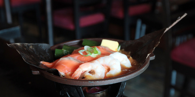 The salmon came to the table on a spirit burner. Photo / Doug Sherring