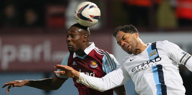 West Ham striker Carlton Cole (left) heads the ball under pressure from Man City defender Joleon Lescott as City cruise into the League Cup final. Photo / AP