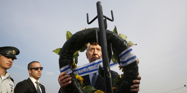 Israel's President Shimon Peres lays a wreath during the funeral of former Israeli Prime Minister Ariel Sharon. Photo / Getty Images