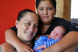 Hera Dawn Chaffey and her speedy baby Te Uira Teremana Van-Lee Chaffey receive a cuddle from birthday boy and proud older brother Taiariki Chaffey. Photo / Paul Rickard