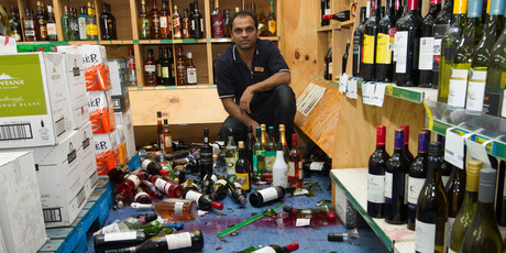 Eketahuna 4 Square manager Tanmay Patel among wines bottles dislodged by the earthquake in their liquor store. Photo / Mark Mitchell