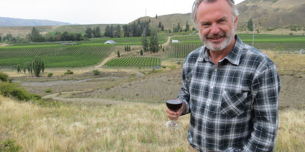 Two Paddocks founder and actor Sam Neill toasts his winery's new acquisition of a fourth vineyard in Central Otago, the 6ha Desert Heart in Bannockburn, seen behind him. Photo / James Beech