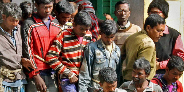 Thirteen men arrested in the Monday night gang rape of a woman are produced at a courthouse. Photo / AP
