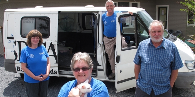 Bay of Islands SPCA receptionist Glenda Norton (left), office/cattery manager Bev Holdsworth (with Smokey Bear), rescue truck driver George Adams and manager John Logie have two things to celebrate - an arrest and a new van. Photo/Peter de Graaf