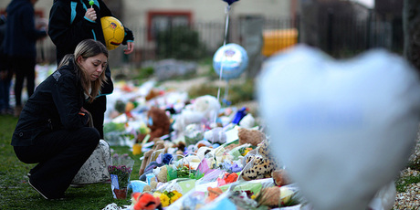 Members of the public lay flowers and candles near to the house in Ferry Gait Crescent where three year old Mikaeel Kular was reported missing. Photo / Getty Images