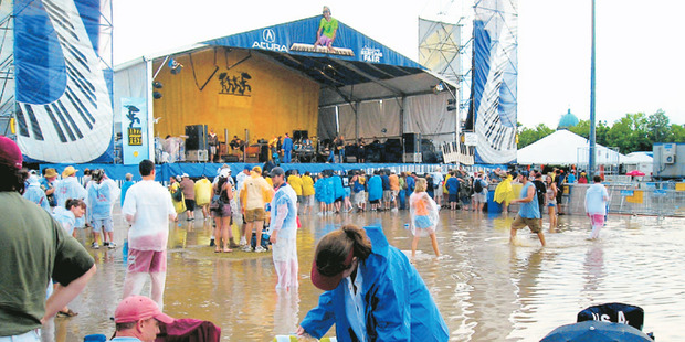 A thunderstorm drenches the ground during New Orleans' annual jazz festival - a reminder of the city's vulnerability to extreme weather. But action soon resumed.