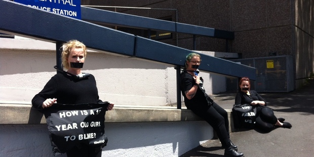 Three women are protesting against the decision not to prosecute the Roast Busters outside the Auckland Central Police headquarters today. Photo / Sam Boyer