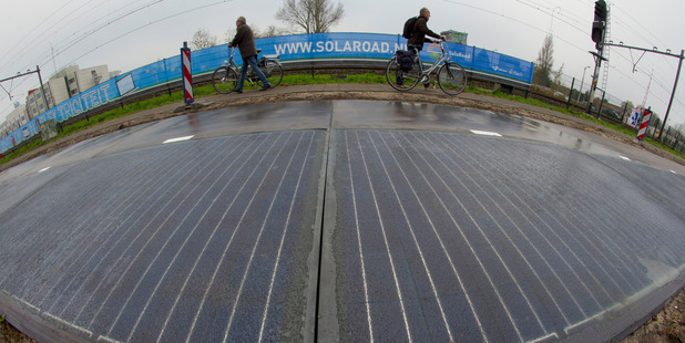 Cyclists are forced to use the pavement passing a stretch of bicycle path where a solar panel roadway is being constructed in Krommenie, north of Amsterdam. Photo / AP