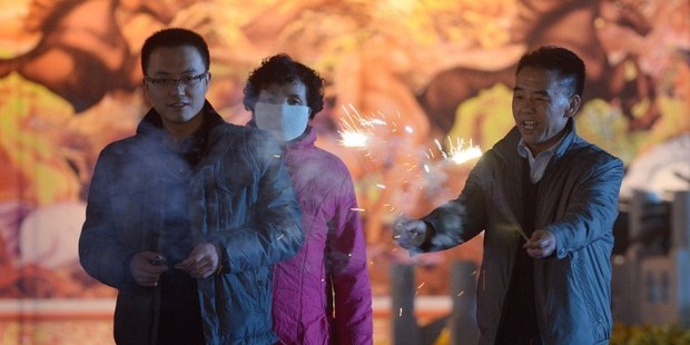 A Chinese family lights fireworks at a square in Lanzhou, northwest China's Gansu province on the eve of the Lunar New Year. Photo / AFP