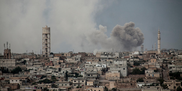 Smoke rises after a bomb was thrown from a helicopter, hitting a rebel position during heavy fighting between troops. Photo / AP