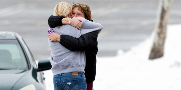 Two people embrace in the parking lot at the scene of a shooting at The Mall in Columbia. Photo / AP
