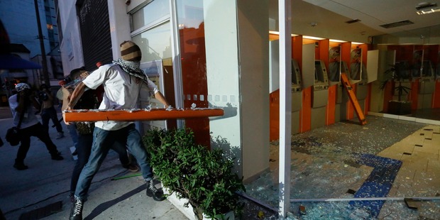 Demonstrators destroy a bank to protest the upcoming World Cup soccer tournament and demand better public services in Sao Paulo, Brazil. Photo / AP