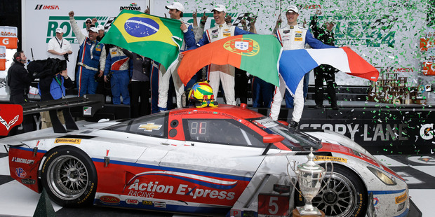 The Action Express team, from left, Christian Fittipaldi, of Brazil, Joao Barbosa, of Portugal and Sebastien Bourdais, of France celebrate in Victory Lane after winning the IMSA Series Rolex 24 hour