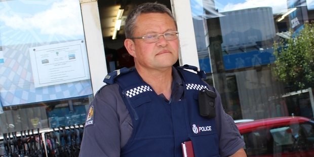 Senior constable Dave Kirk of the Pongaroa Police guards the door to Dannevirke's Coin Save early yesterday afternoon after police swooped on the premises. Photo/Christine McKay