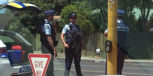 Armed police lock down an area of Takanini yesterday after the carjacking at gunpoint.