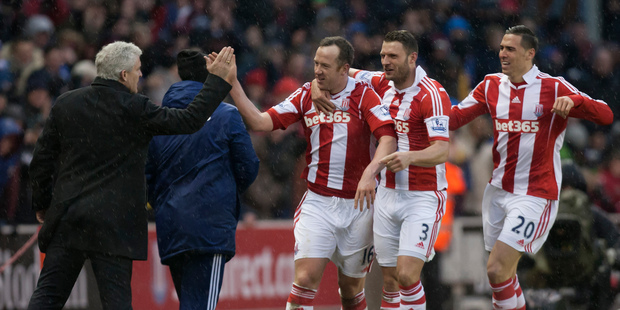 Stoke's Charlie Adam, centre, celebrates with teammates and manager Mark Hughes, left, after scoring his second goal against Manchester United. Photo / AP