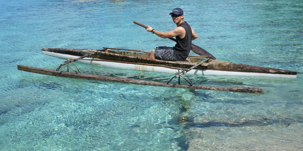 Andrew Louis paddles a traditional outrigger canoe in Niue's crystal-clear waters. Photo / Andrew Louis