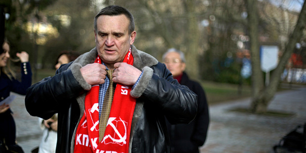 Igor Vasiliyev, head of the local branch of the Communist Party, adjusts his scarf decorated with a hammer and sickle. Photo / AP