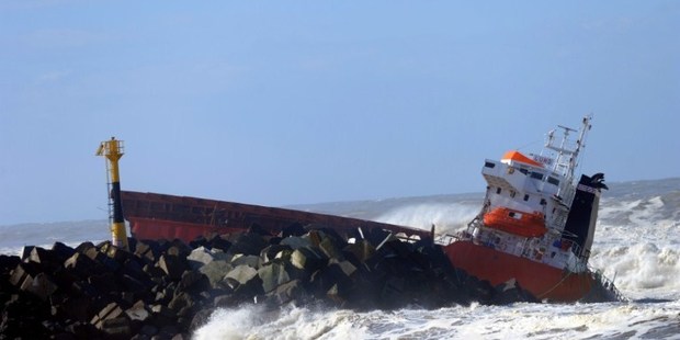 A helicopter hovers over the hundred meter long 'Luno' Spanish cargo ship containing diesel fuel which crashed into a dyke and split in two. Photo / AFP