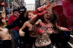 Activists with body painting reading 'abortion is sacred' protest in Madrid in November. Photo / AFP