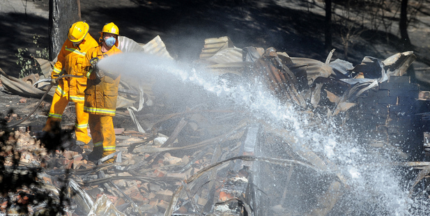 Members of the CFA put out smothering fires in the Melbourne north east suburb of Warrandyte. Photo / AAP