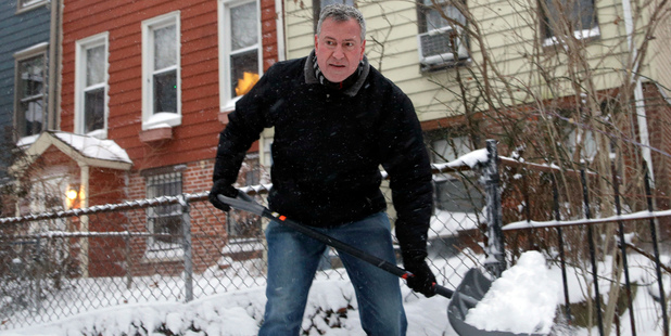 New York City Mayor Bill de Blasio shovels the sidewalk in front of his house in New York. Photo / AP