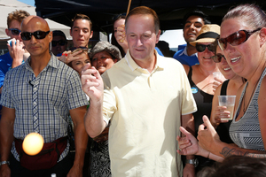 John Key plays beer pong at the Big Gay Out. Photo / Dean Purcell