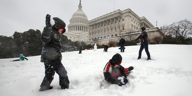 Children play in the snow on Capitol Hill, as winter weather shut down Washington. Photo / AP