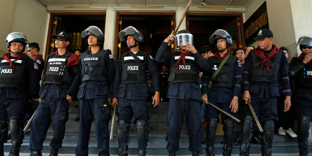 Police in riot gear stand guard as anti-government protesters aimed at disrupting government offices push through the entrance to the Department of Forestry in Bangkok, Thailand. Photo / AP