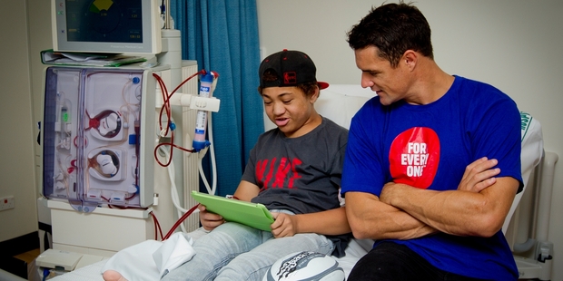 Jizavier Henry gives one of the donated iPads a try-out yesterday after All Black Dan Carter (right) presented them at the Starship. Photo / Sarah Ivey