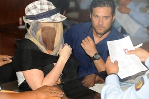 Schapelle Corby, her face covered, sits at a correction bureau in Denpasar on Indonesia's resort island of Bali. Photo / AFP