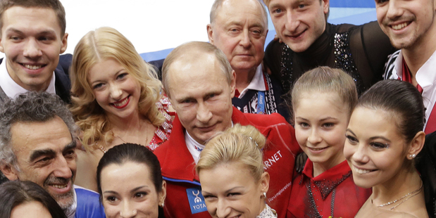 Russian President Vladimir Putin, centre back, poses for a photograph with the Russian team after they placed first in the team figure skating competition. Photo / AP