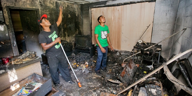 Housing NZ workers Shane Nur and Krishnil Nand survey the damage at the Birkinhead flats. Photo / Greg Bowker