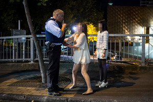 A distraught woman speaks to an officer. Photo / Michael Craig