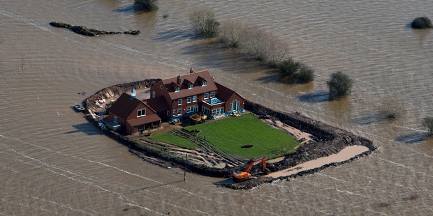 Flood waters inundate the area as one house stands alone near the flooded village of Moorland in Somerset, southwest England. Photo / AP