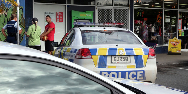 Police speak to shoppers after the Otaika Lotto and PostShop was robbed at gunpoint. PHOTO/JOHN STONE