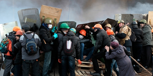 Anti-Government protesters in Kiev, who have lost vital defences to riot police, protect themselves with shields. Photo / AP