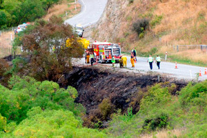 Emergency services personnel work to retrieve the body of a motorist killed in the crash