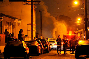 Police and Fire Service personnel attend a fire at a large party in Hyde St on Saturday night, where four men were arrested. Photo / Craig Baxter