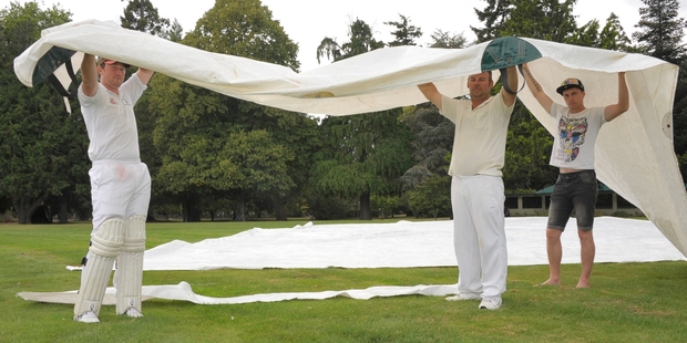 DAMAGE DONE: Red Star players Chris Wendon, left, Richard Payton and Lance Gilmour with the ground covers which were damaged by vandals at Queen Elizabeth Park oval on Friday night.