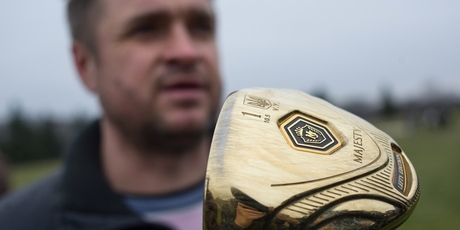 A man holds a golf club with the name of Ukrainian President Viktor Yanukovych. Photo / AP