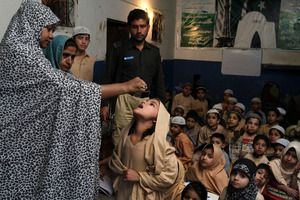 A Pakistani health worker vaccinates a schoolgirl against polio, in Pakistan, where there are still outbreaks of the disease.
Photo / AP