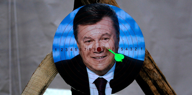 A portrait of Ukraine's embattled president Viktor Yanukovych is used for a game of darts at Independence Square in Kiev, Ukraine. Photo / AP