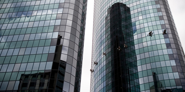 A team of about seven abseiling window washers make their way down the Phillips Fox Tower Herald Photo / Dean Purcell.