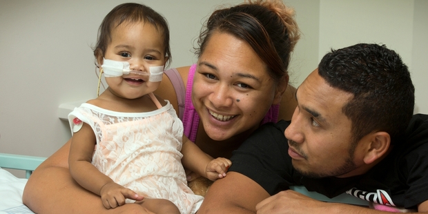 One-year-old Mere-Takutai Pomana, who is beginning a long recovery, with her parents Tessa Thornton and John Pomana at the Starship hospital. Photo / Brett Phibbs