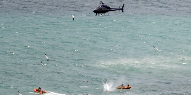 The policeman shoots the shark at Muriwai a year ago today in an attempt to retrieve Adam Strange's body.