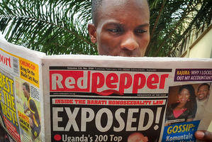 A Ugandan reads a copy of the Red Pepper tabloid newspaper in Kampala, Uganda. Photo / AP